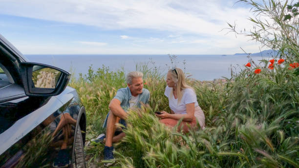 istock Mature couple relax on hill top with car 2153195266