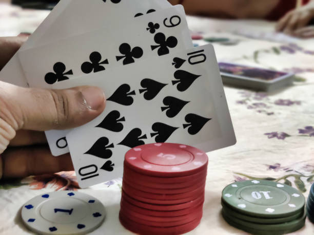istock Poker playing chips arranged and a person holding cards 2153195270
