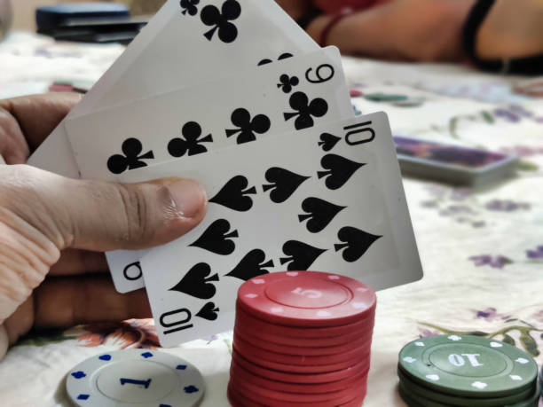 istock Poker playing chips arranged and a person holding cards 2153195273