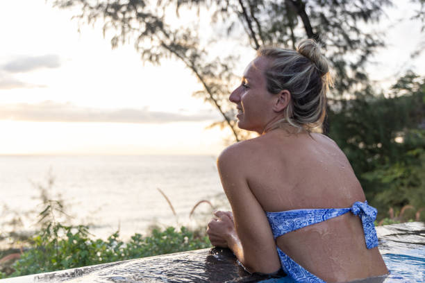 istock Happy Woman On Vacation Relaxing in Infinity Pool at Sunset 2153200731
