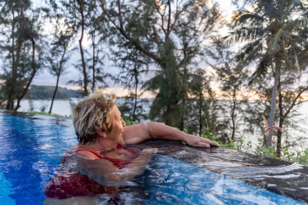 istock Senior Woman Relaxing in an Infinity Pool 2153200781