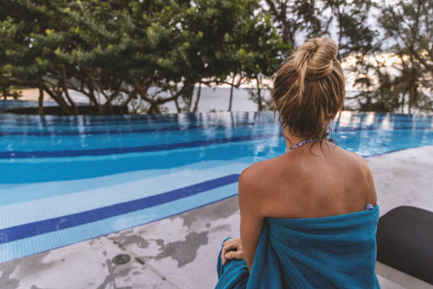 Portrait of a beautiful woman relaxing at a spa with eyes closed and holding a towel - wellness concepts