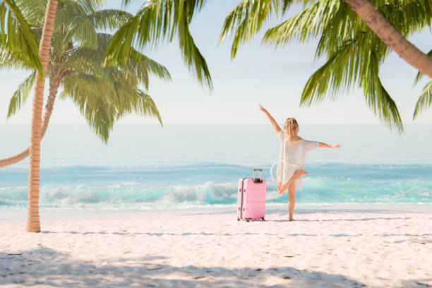 Joyful Woman Celebrating Arrival at Tropical Beach with Suitcase
