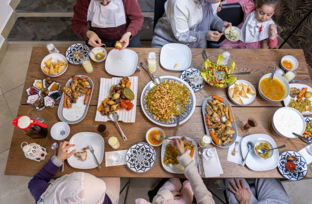 istock A Muslim family gathers around a rectangular table, sharing a heartwarming meal together, with members of various ages adding to the warmth and joy of the occasion 2153211893