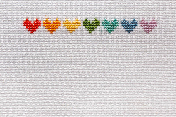 istock Seven rainbow-colored hearts are embroidered on white fabric. 2153212790