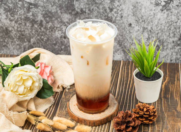 istock Iced Fresh milk black tea with ice cube served in disposable glass isolated n table side view of taiwanese drink 2153218167