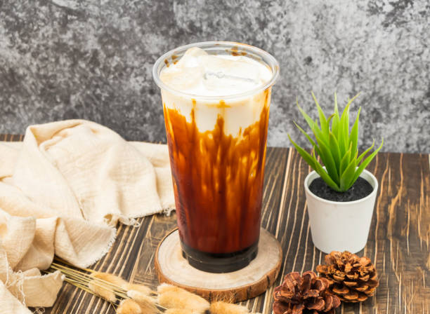 istock iced Brown sugar milk tea with ice cube served in disposable glass isolated n table side view of taiwanese drink 2153218293