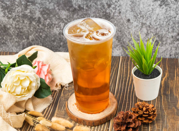 istock iced Ancient wheat tea with ice cube served in disposable glass isolated n table side view of taiwanese drink 2153218294