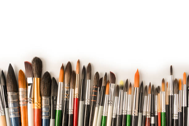 Mix of paint brushes in a row isolated on a white background.  Top view.