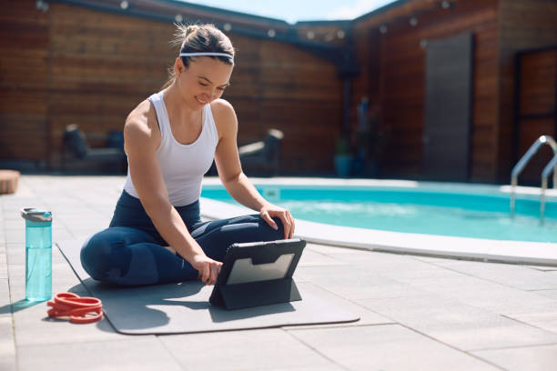 istock Happy athletic woman using digital tablet while exercising outdoors. 2153220104