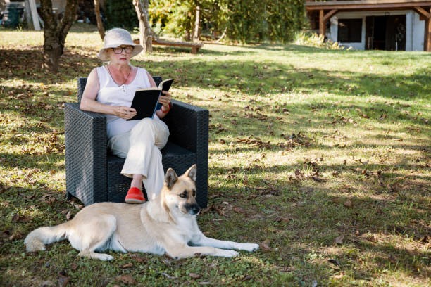 istock Senior lady Enjoying in book outside home 2153221318
