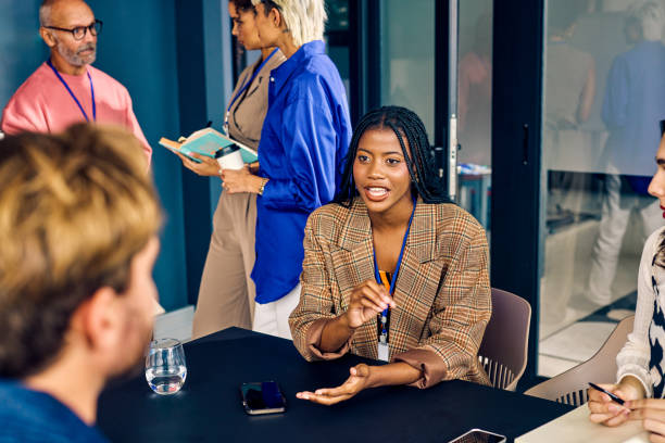 istock Gen Z co-worker discussing strategies with a colleague during a creative meeting. Multitasking and team collaboration in a diverse office environment concept. 2153221975