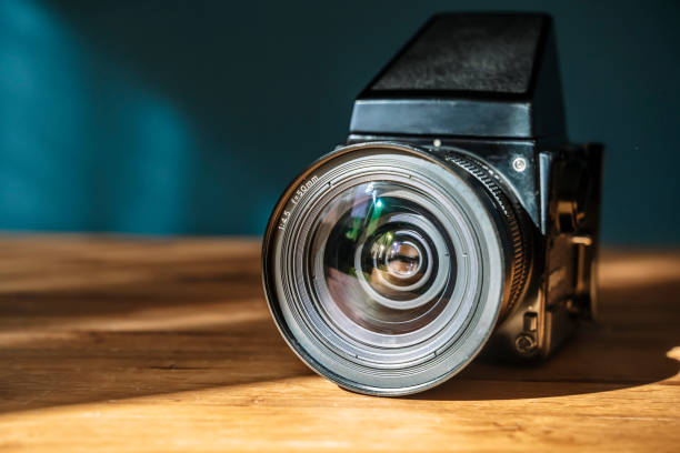 istock Camera is on the table. Medium format analog film camera on a blank background. Retro vintage technology style 2153228438