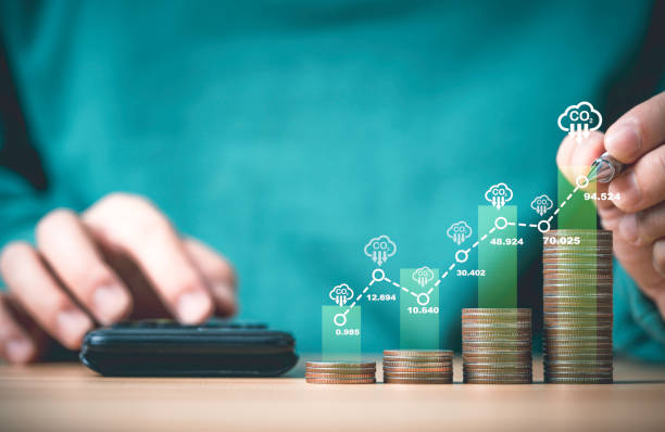 istock Businessman writing increasing graph on coins stacking with carbon reduction icon for carbon credit and footprint to limit global warming from climate change, Bio Circular Green Economy concept. 2153230018