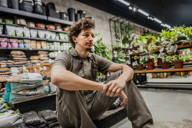 Worried young trainee man at flower shop