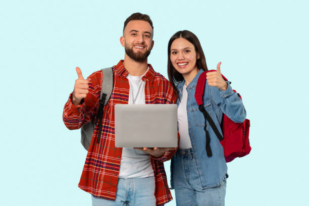istock Couple with backpacks giving thumbs up on blue background 2153233227