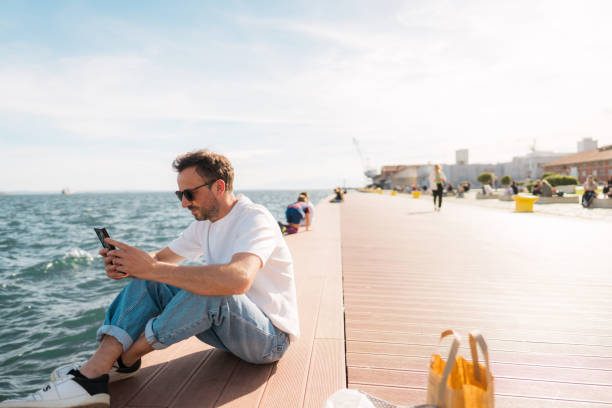 istock Man sitting on the pier 2153233238