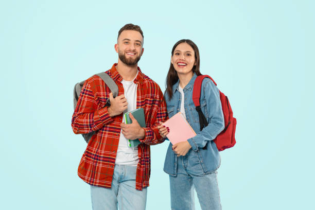istock students man and woman standing with backpacks and books, studio 2153233239