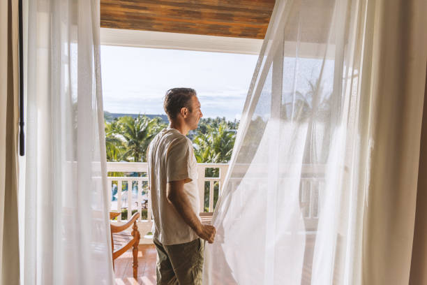 istock Man Enjoying Morning View from Tropical Balcony 2153237207