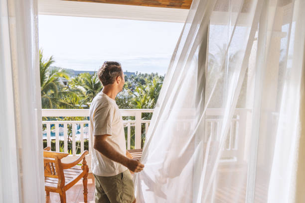 istock Man Enjoying Fresh Air on Tropical Balcony 2153237215