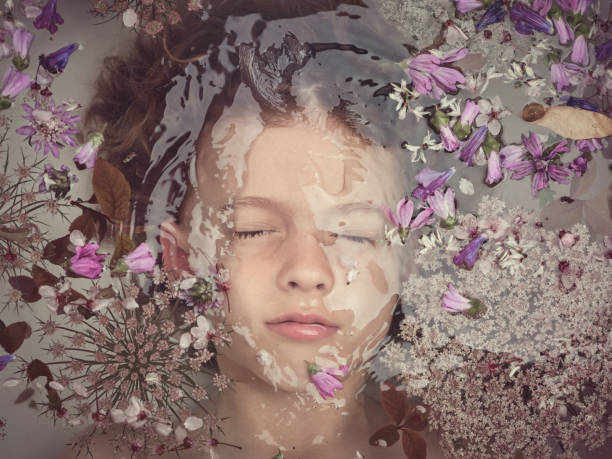 istock Boy lying underwater in bathtub with flowers 2153244605