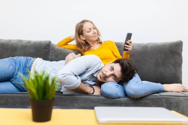 istock boy lying on girlfriend's lap while she is looking at smart phone 2153245891