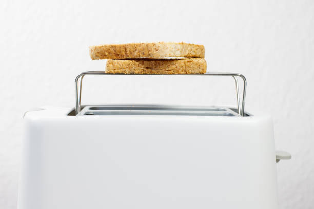 toaster with toasted slices of bread on a gray background