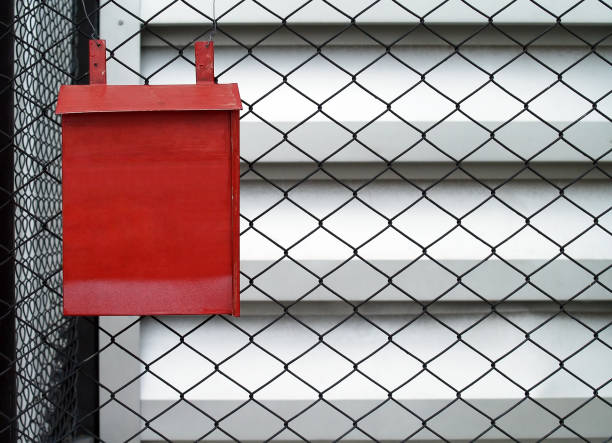 vintage metallic letterbox decorating chain link fence outside house