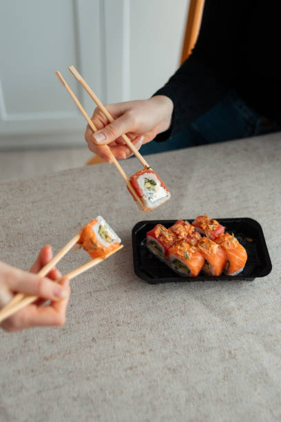 istock Sushi delivery. Set of rolls in a disposable box on a black background. Top view 2153263969