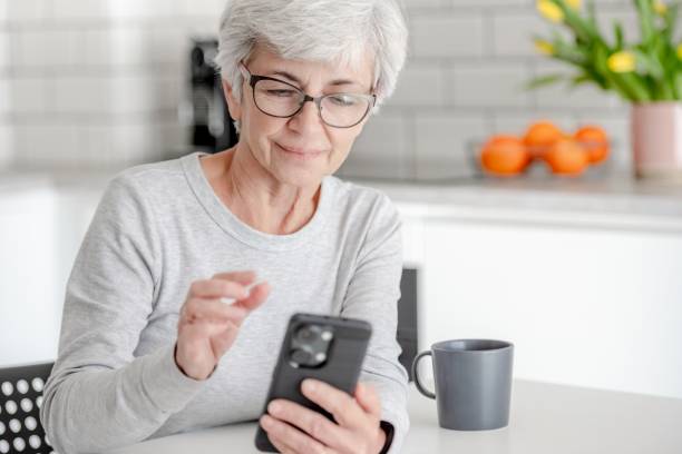 istock Grey-Haired Attractive Woman Searches For Information On Phone 2153267213