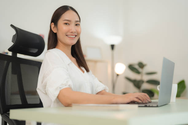 istock Young woman working on laptop in modern office 2153269529