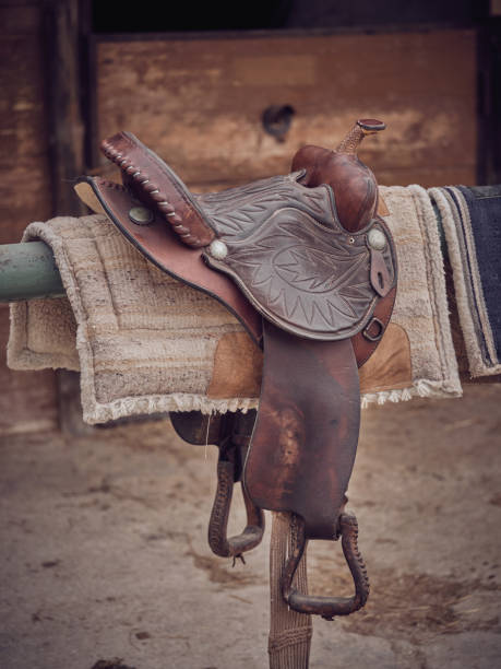 istock Saddle against shabby wooden stable 2153278178