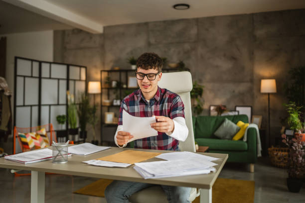 istock Young caucasian man with eyeglasses sit and study for exam at home 2153286287