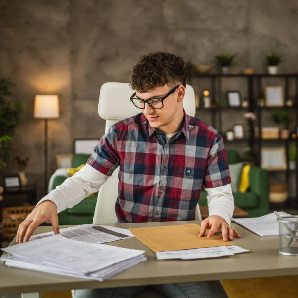 istock Young caucasian man with eyeglasses sit and study for exam at home 2153287064