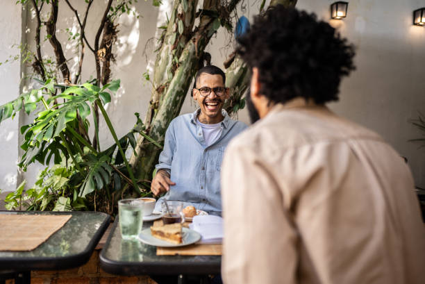 istock Young man talking with friend at coffee shop 2153287494