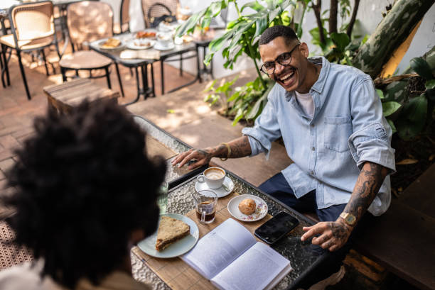 istock Young man talking with friend at coffee shop 2153287495
