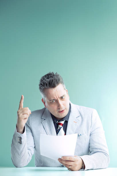 istock Anchorman points up, alarmed, reading shocking news 2153287528