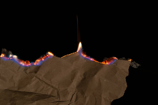 istock burning paper, glowing edge of paper on a black background 2153290362