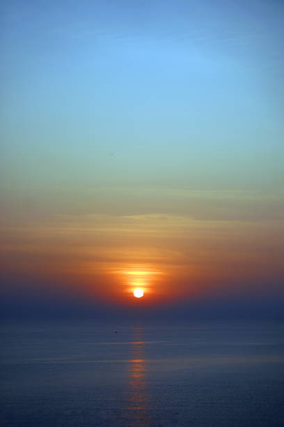 istock The setting sun casts a golden glow on the ocean. 2153300640