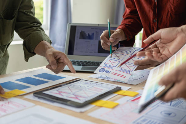 istock A team of UX designers works on a new website layout. Plan mobile web application development in prototyping. product development and adding new ideas 2153302220