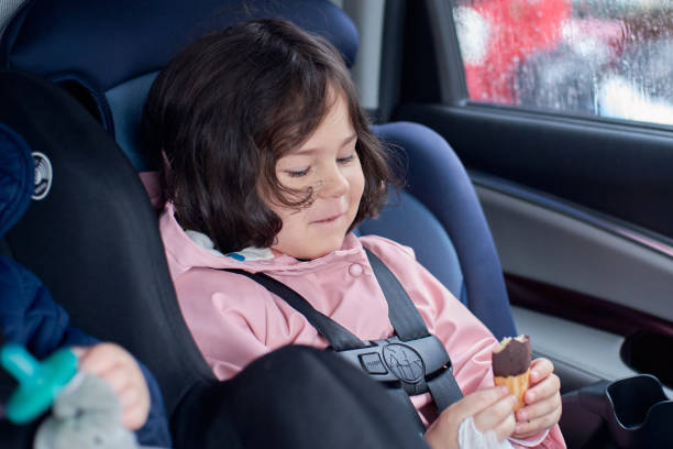 istock siblings in car seats having snacks in the back seat on a rainy day 2153302406