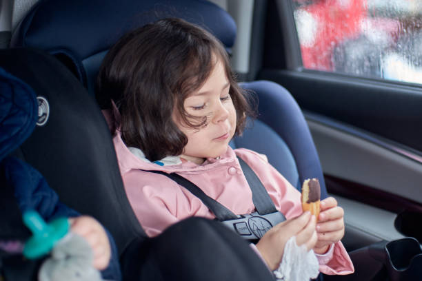 istock siblings in car seats having snacks in the back seat on a rainy day 2153302409
