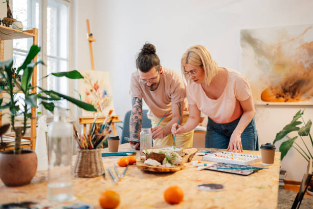 istock Young hipster artists at art studio with brushes in hands and painting 2153302769