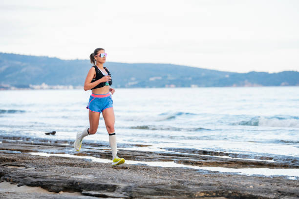 Female jogger exercising on the beach.She is jogging alongside the coastline.