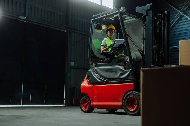 istock Female forklift driver sitting and reading paperwork 2153303558