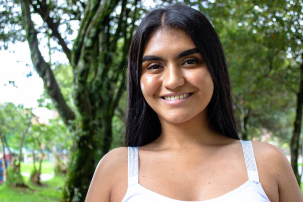 istock Beautiful young woman posing in a park 2153308127