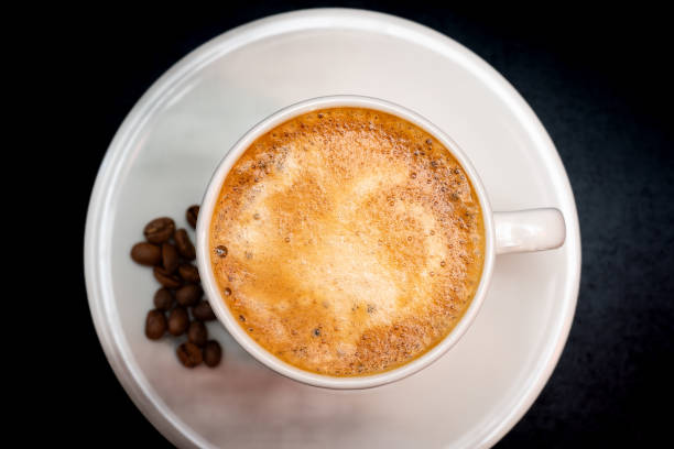 istock Cup of hot drink with steam over black background 2153311486