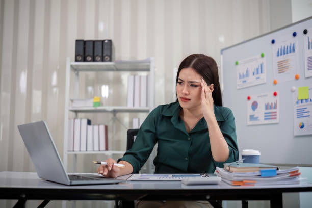 istock Stressed overwhelmed businesswoman working with computer laptop while having headache in the office 2153321298