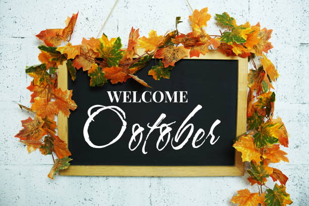 istock Hello October text message on Blackboard decoration with maple leaves hanging on a concrete wall background 2153326609