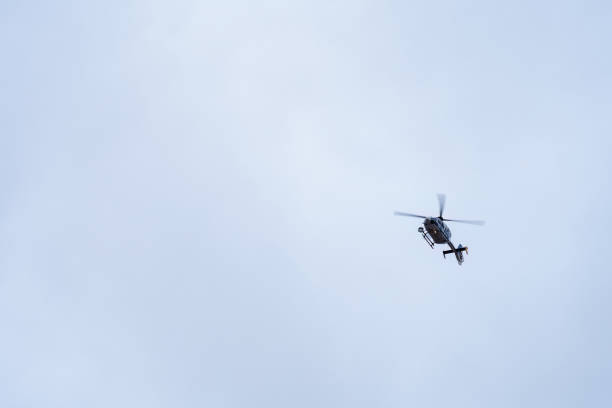 Police helicopter flying through the overcast sky in Spain.